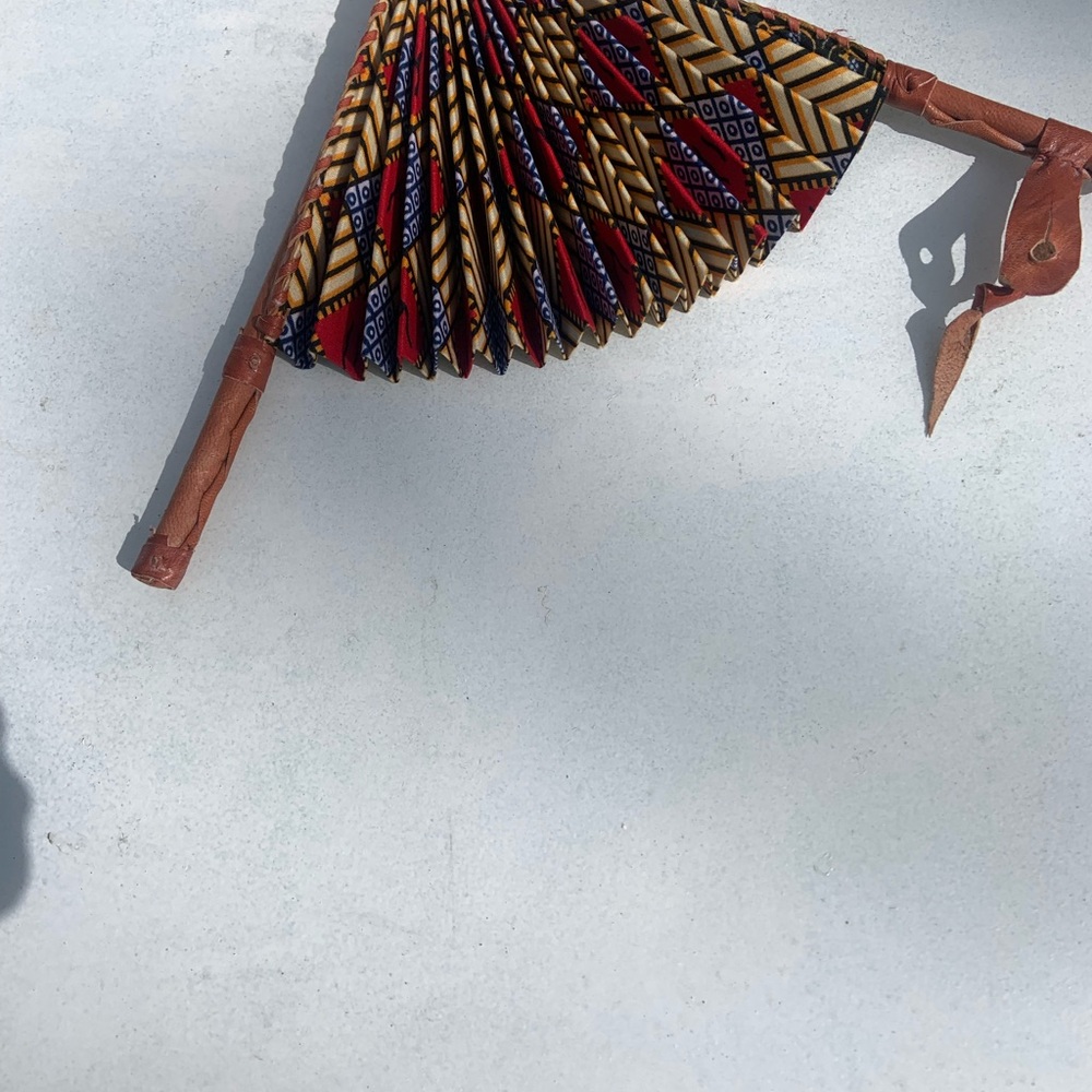 African fan made out of leather trimmings and African fabric.